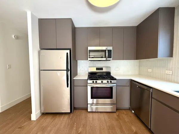 a kitchen with a refrigerator and a stove top oven