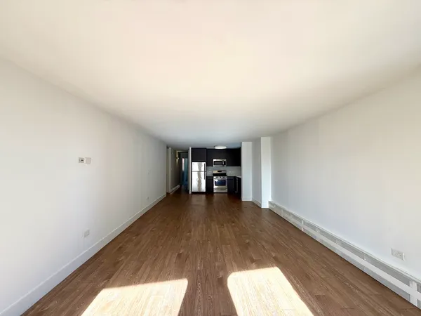 a view of empty room with wooden floor