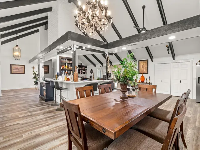 a kitchen with stainless steel appliances kitchen island granite countertop a table chairs in it and wooden floors