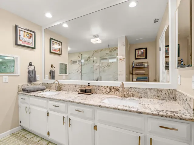 a bathroom with a granite countertop sink mirror and shower