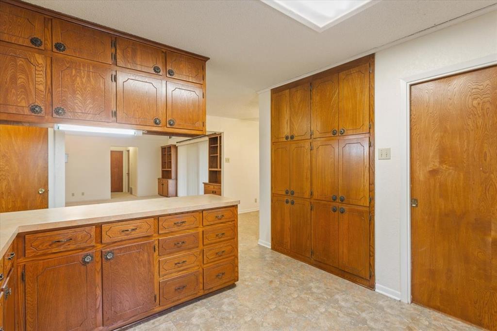 208 South Hedwig Street Riesel, TX 76682 - Photo 16 of 31 Kitchen featuring brown cabinetry and light countertops