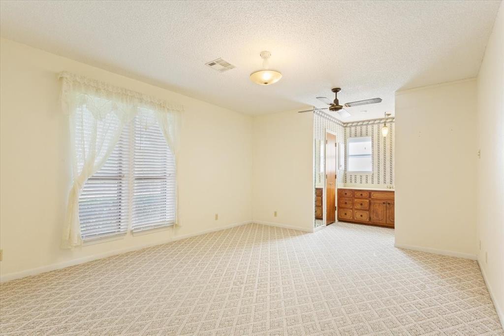 208 South Hedwig Street Riesel, TX 76682 - Photo 20 of 31 Carpeted spare room featuring a textured ceiling and a ceiling fan