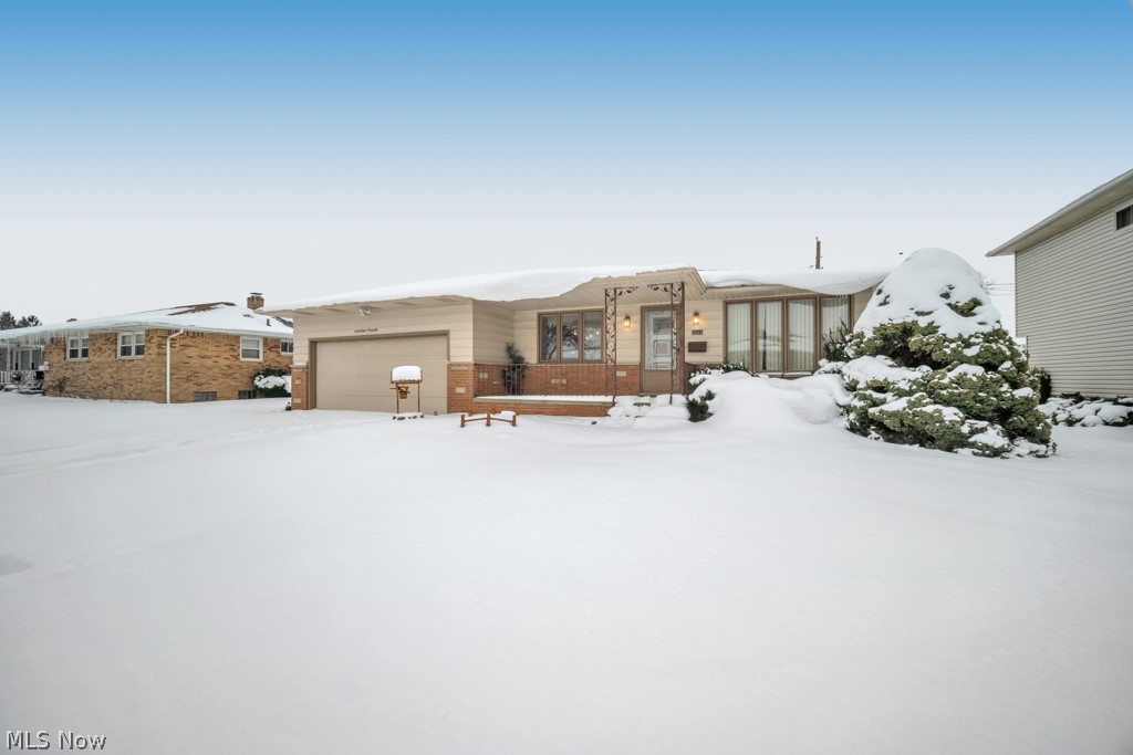 6846 Revere Road Cleveland, OH 44130 - Photo 4 of 30 Snow covered house featuring brick siding and an attached garage