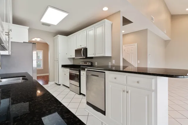 a kitchen with white cabinets a sink and a window