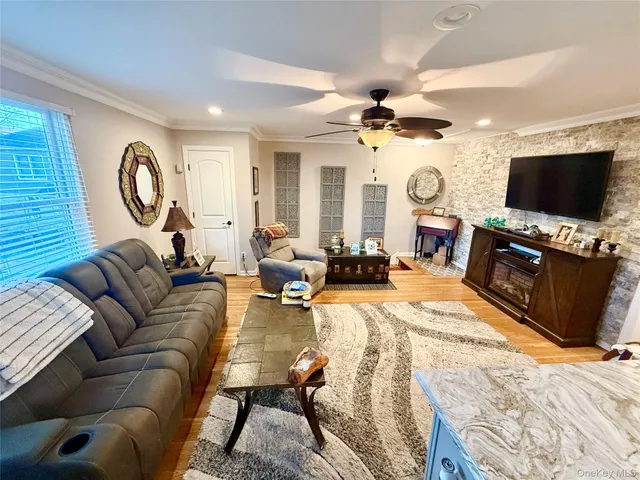 a living room with furniture a flat screen tv and a large window