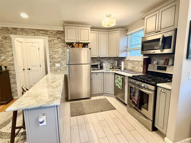 a kitchen with granite countertop a refrigerator stove top oven and sink