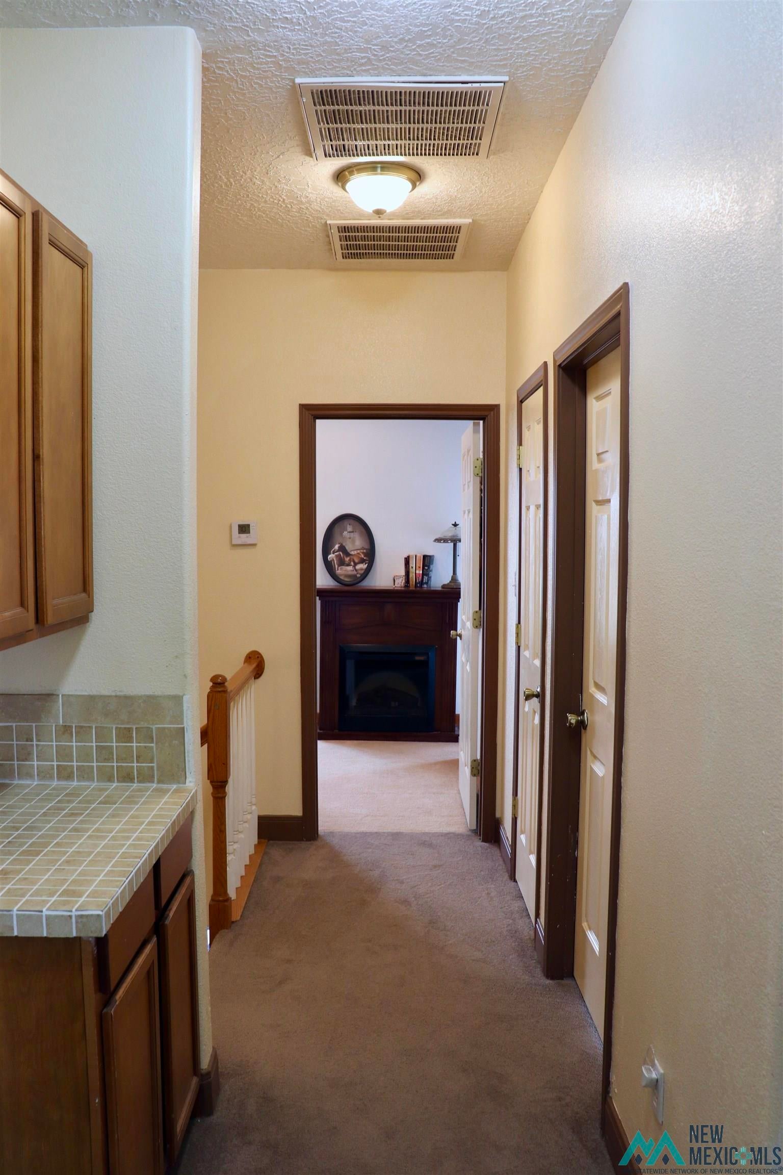 845 South Roosevelt Road South Portales, NM 88130 - Photo 22 of 47 Hall with dark carpet and a textured ceiling