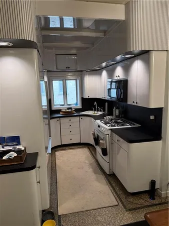 a kitchen with granite countertop a sink a stove and cabinets