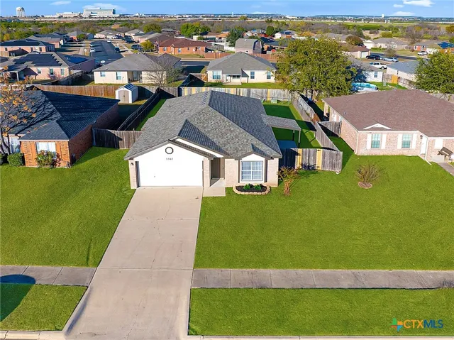 an aerial view of residential houses with outdoor space and parking