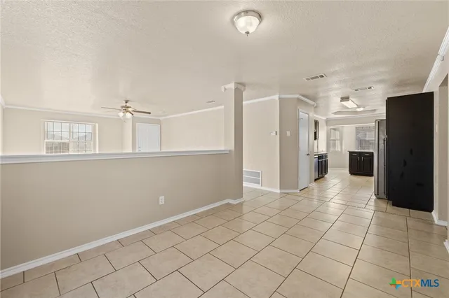a view of a refrigerator in kitchen and white cabinets