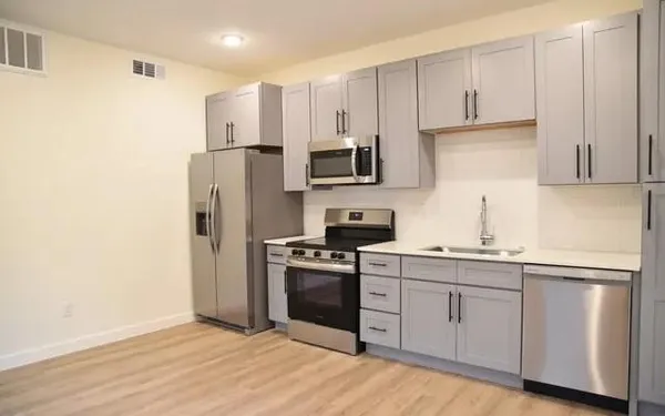 a kitchen with white cabinets stainless steel appliances and sink