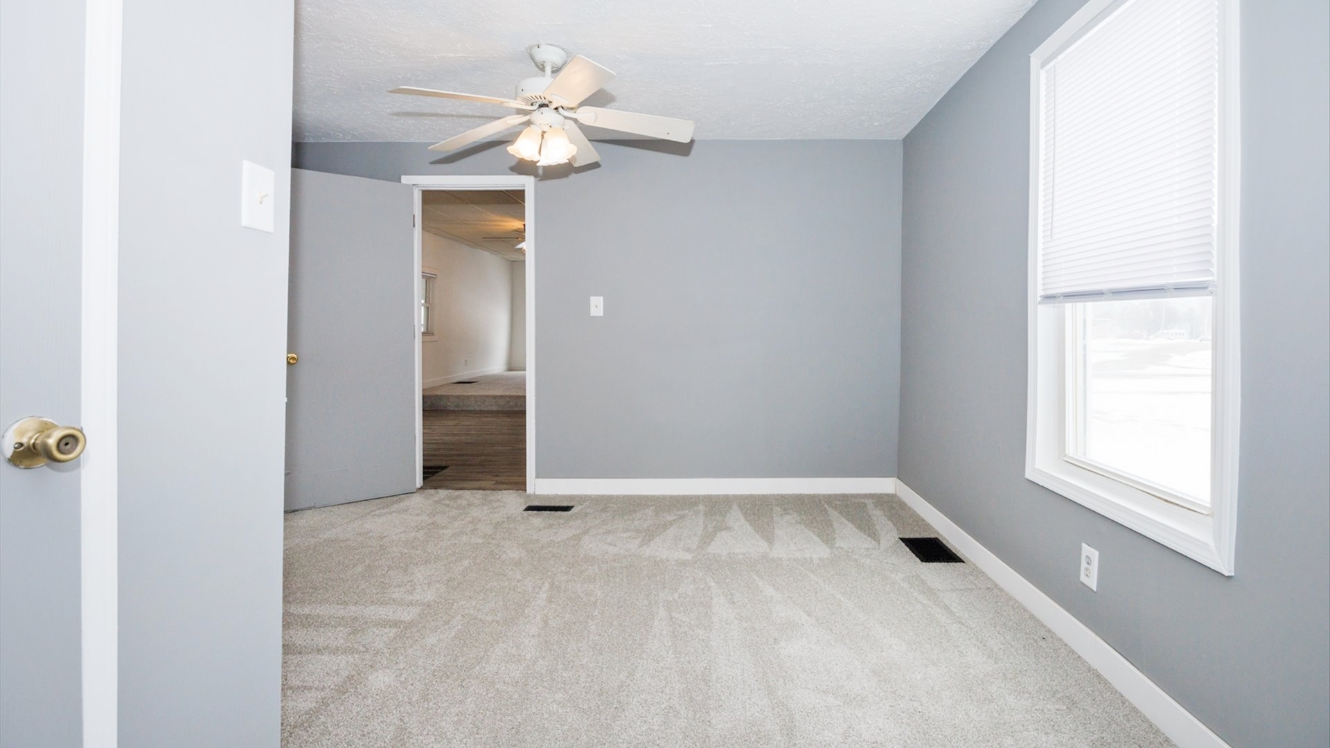 300 East South Street Atlanta, IL 61723 - Photo 31 of 69 an empty room with chandelier fan and windows