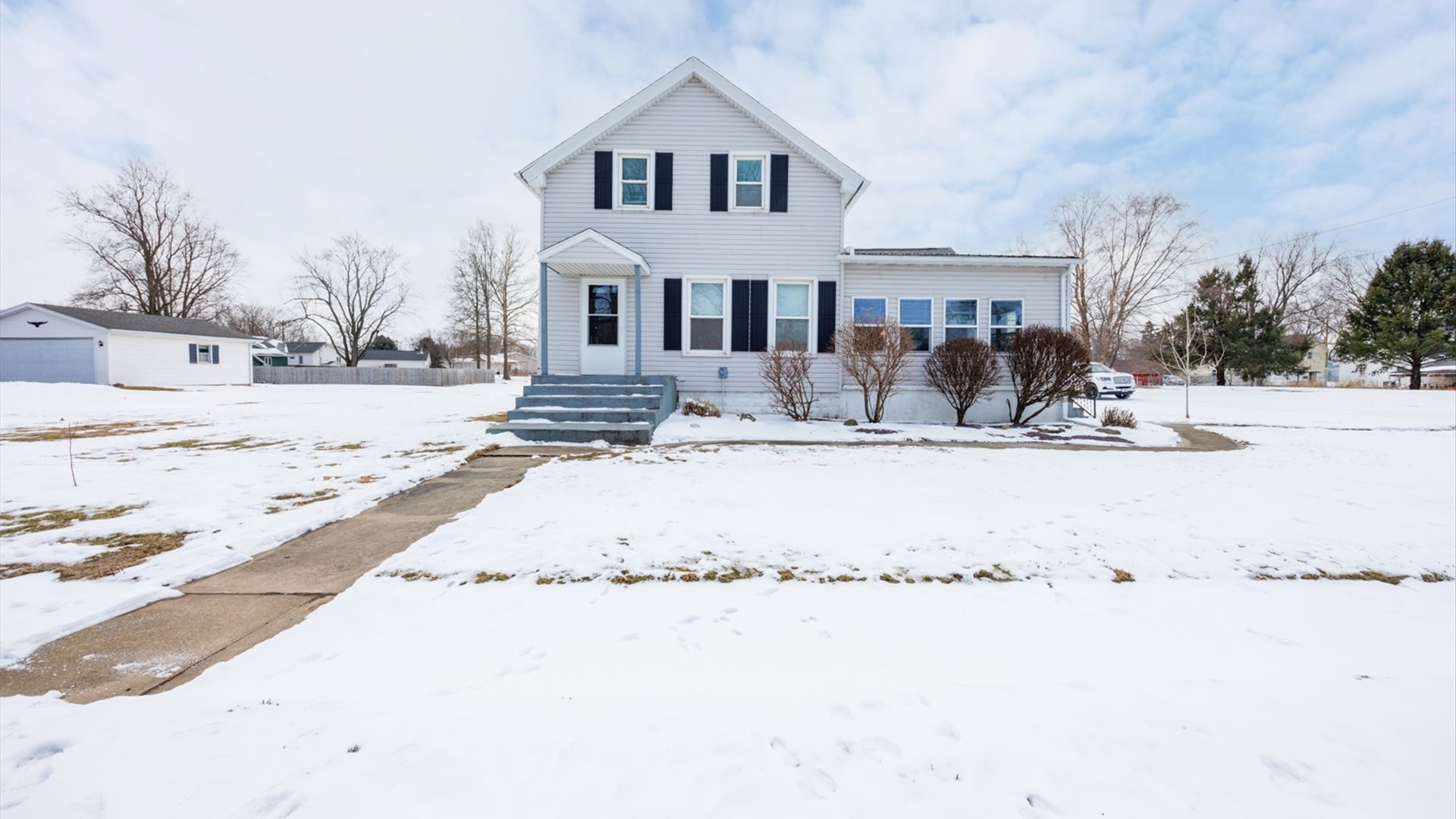 300 East South Street Atlanta, IL 61723 - Photo 60 of 69 a view of white house with a yard covered in snow