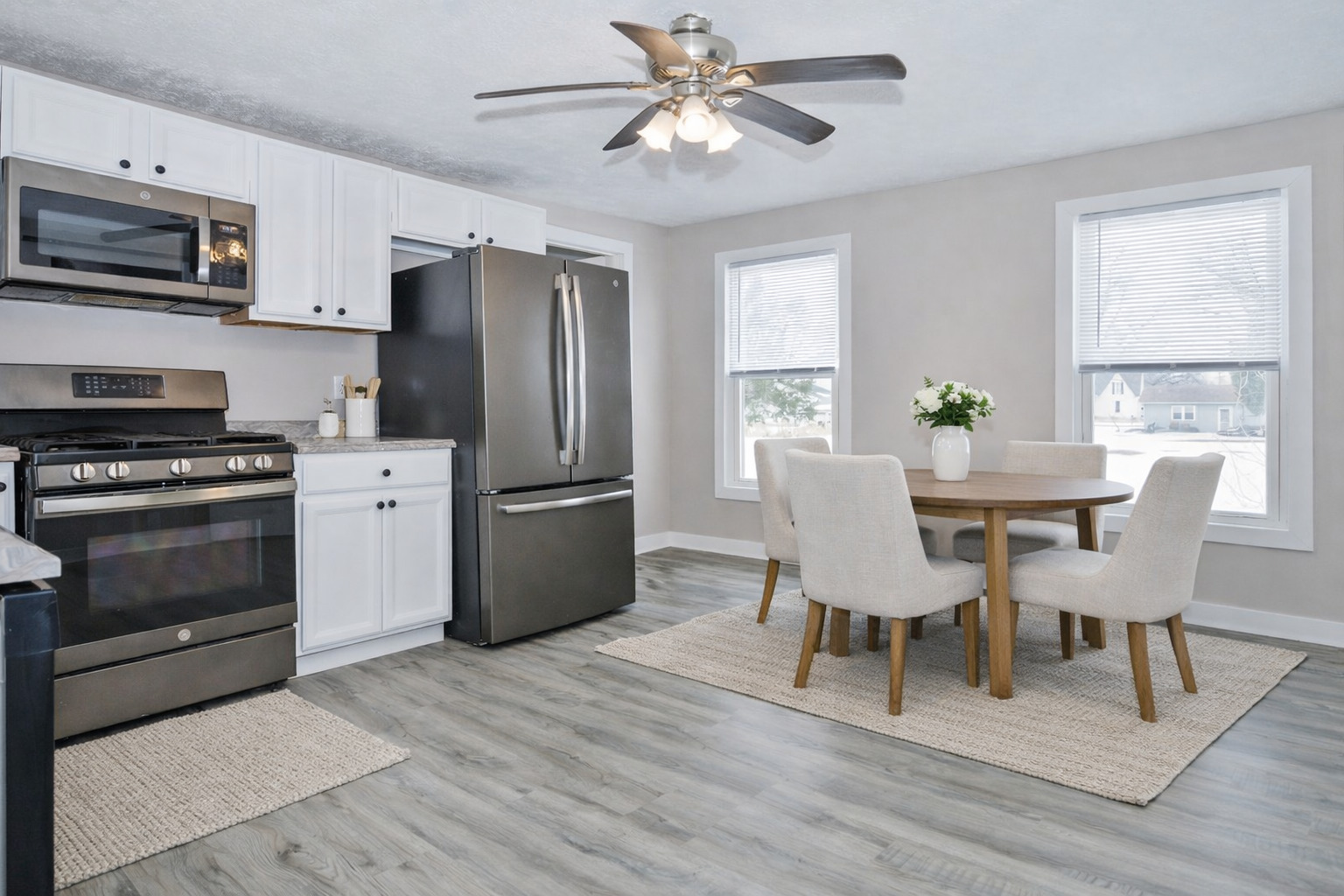 300 East South Street Atlanta, IL 61723 - Photo 6 of 69 a kitchen with stainless steel appliances granite countertop a stove a refrigerator a kitchen island a dining table and chairs with wooden floor