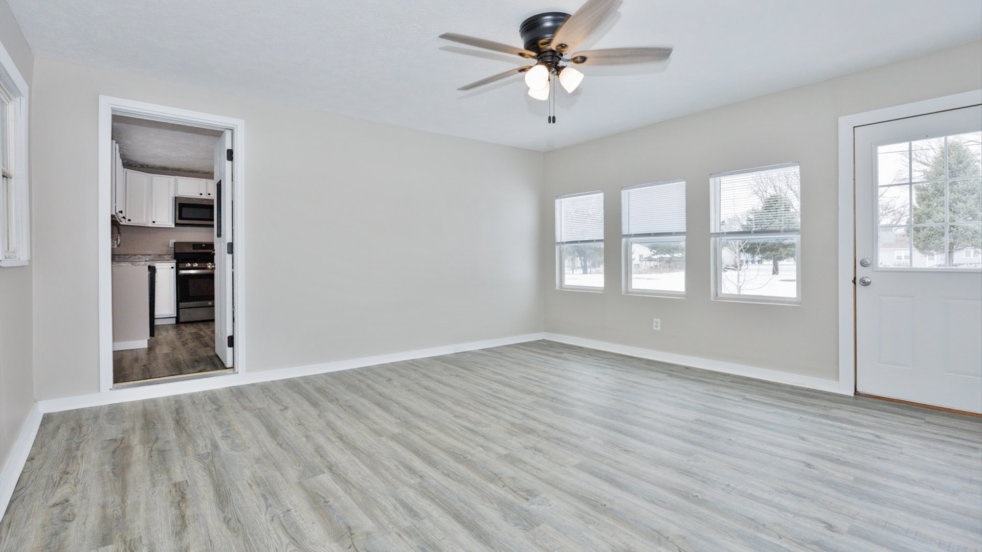 300 East South Street Atlanta, IL 61723 - Photo 8 of 69 an empty room with wooden floor chandelier fan and windows