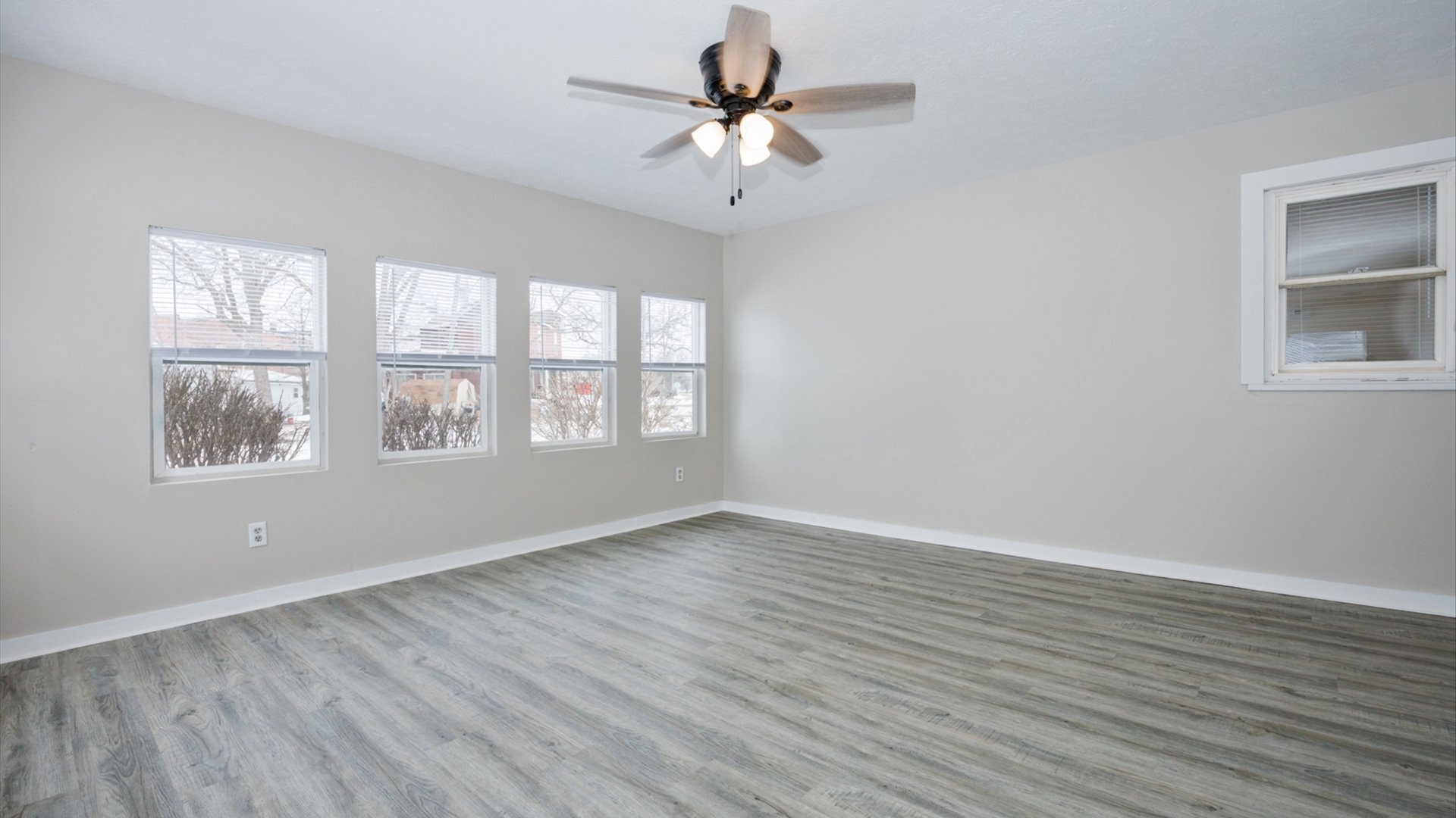300 East South Street Atlanta, IL 61723 - Photo 10 of 69 an empty room with wooden floor chandelier fan and windows