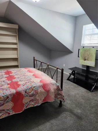 a bedroom with a bed and dresser with view