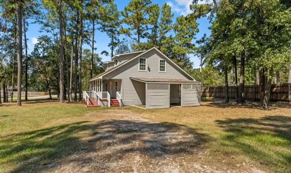 a front view of a house with a yard and trees