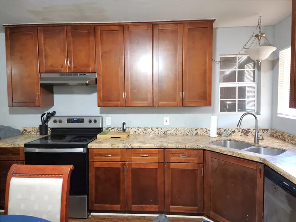 a kitchen with stainless steel appliances wooden cabinets and a stove top oven