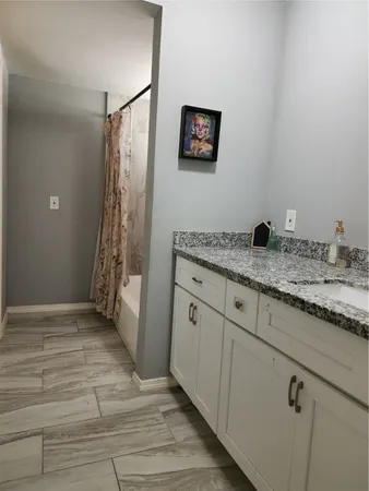 a bathroom with a granite countertop sink a shower and a mirror