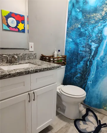 a bathroom with a granite countertop toilet sink and mirror