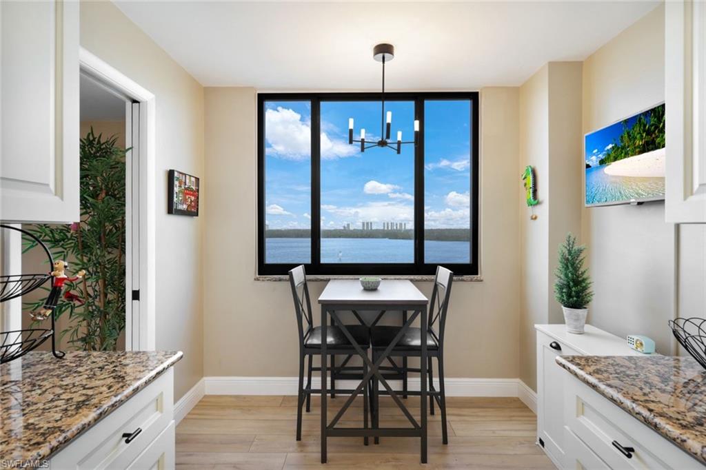 17 Bluebill Avenue, Unit 206 Naples, FL 34108 - Photo 13 of 30 Dining area with light wood finished floors and a chandelier