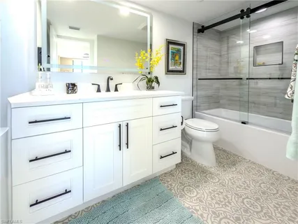 a bathroom with a tub sink and mirror