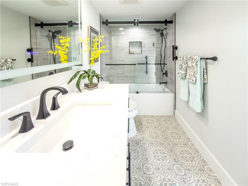 17 Bluebill Avenue, Unit 206 Naples, FL 34108 - Photo 29 of 44 a bathroom with a tub sink and mirror