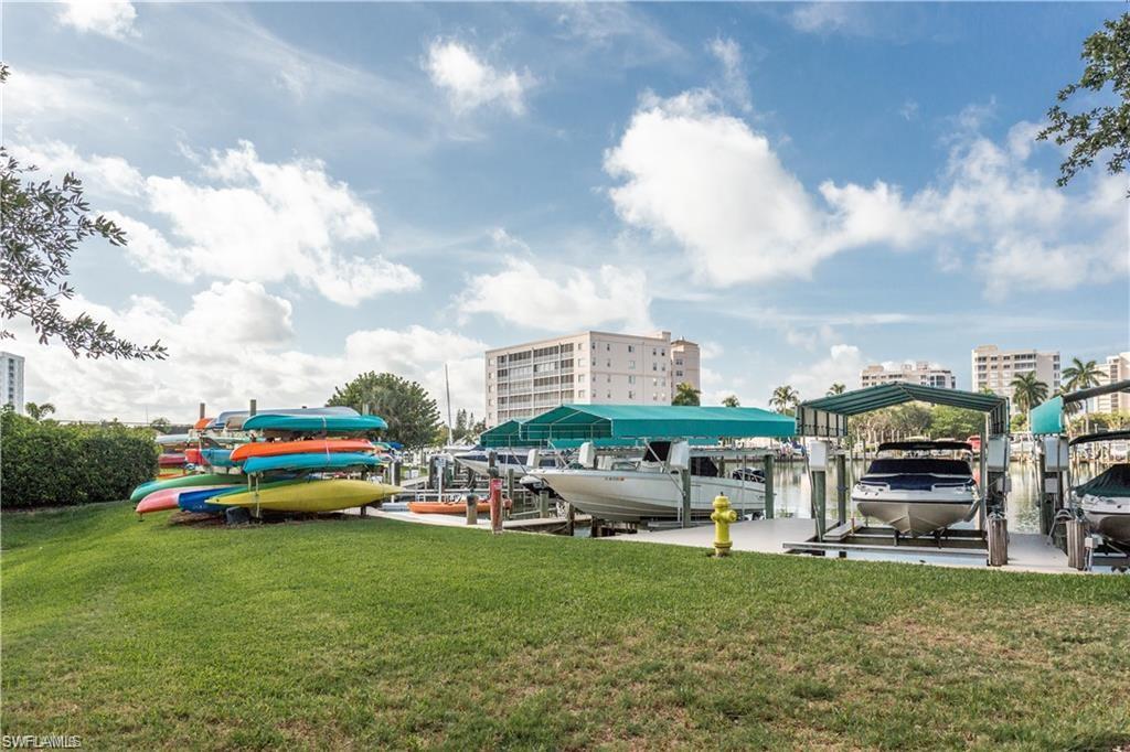 17 Bluebill Avenue, Unit 206 Naples, FL 34108 - Photo 36 of 44 a car parked in front of a house with a big yard