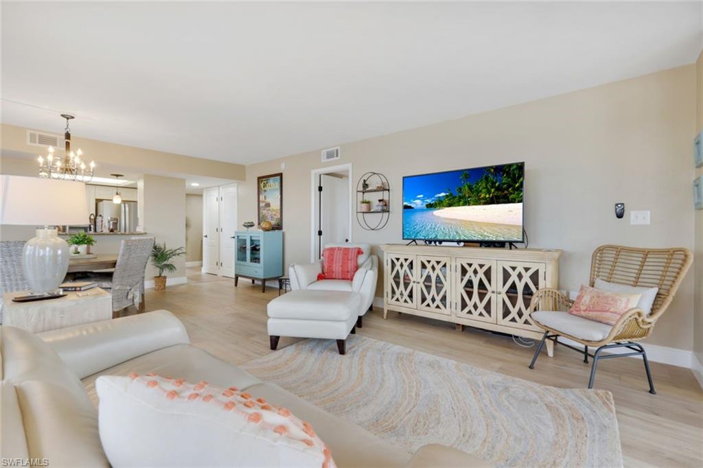 17 Bluebill Avenue, Unit 206 Naples, FL 34108 - Photo 8 of 30 Living room featuring wood finished floors and a chandelier