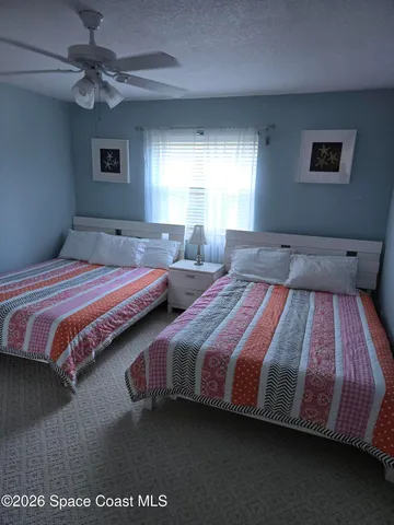 a bedroom with two beds and a chandelier