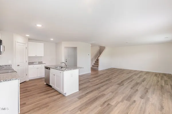 a kitchen with kitchen island wooden floors and white cabinets