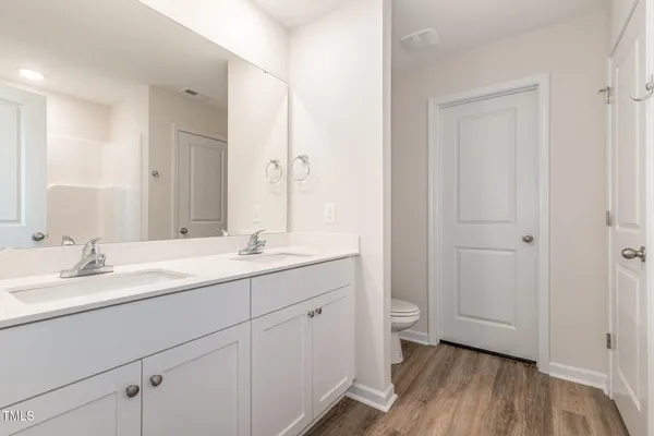a bathroom with a granite countertop sink a toilet and a large mirror
