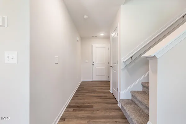 a view of a hallway with a white walls and stairs