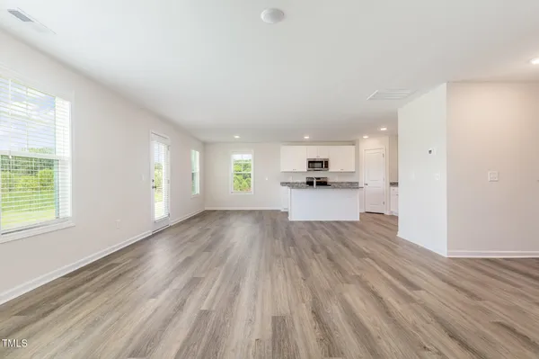 a view of empty room with wooden floor and window