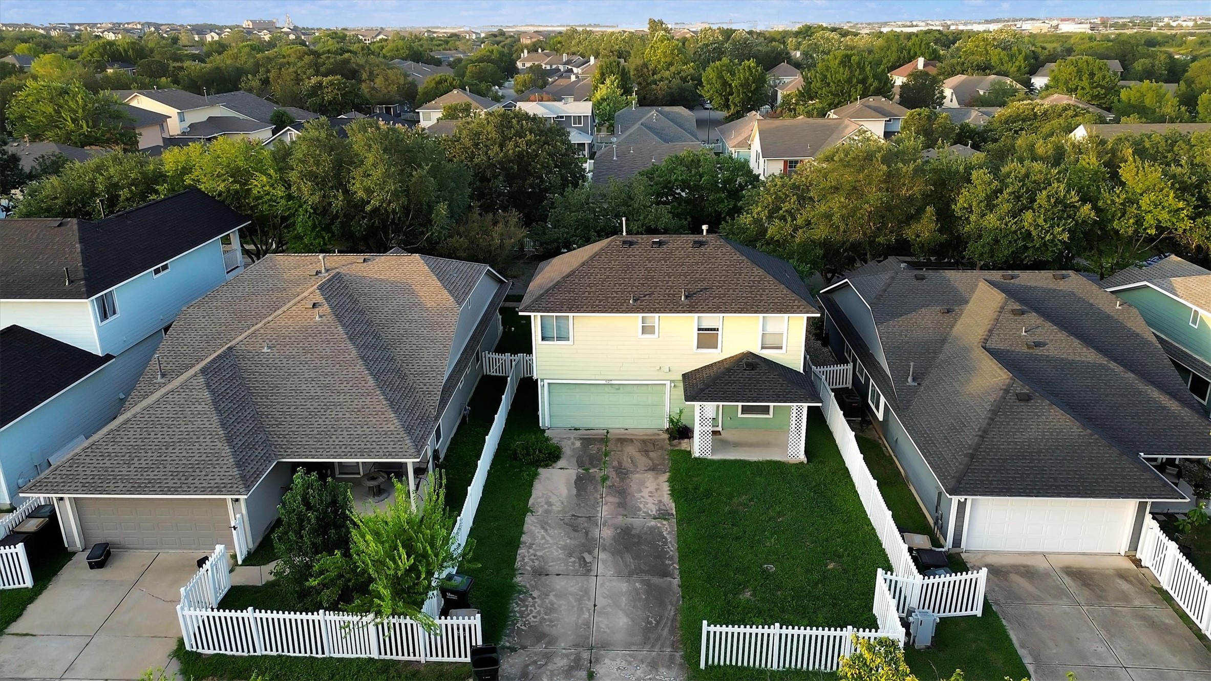 627 Scheel Road Kyle, TX 78640 - Photo 32 of 37 An aerial perspective reveals a cozy home nestled between neighbors, featuring a welcoming covered entry and an attached garage.