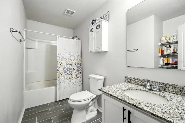 a bathroom with a granite countertop sink toilet and shower
