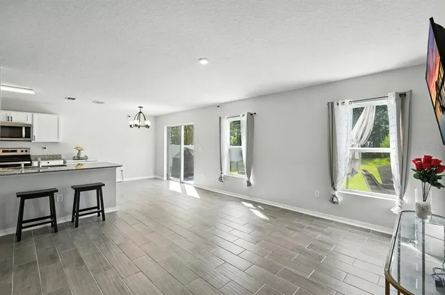 a view of a kitchen with furniture and wooden floor