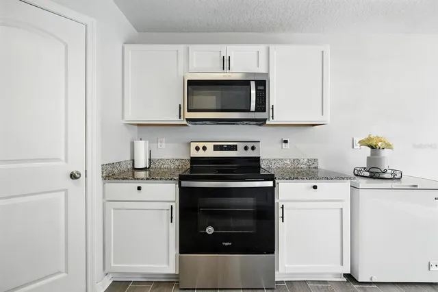 a kitchen with white cabinets and stainless steel appliances