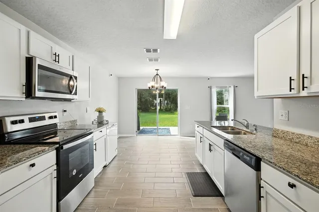 a kitchen with a sink stove top oven and microwave