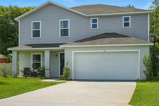 a view of a house with a yard and potted plants