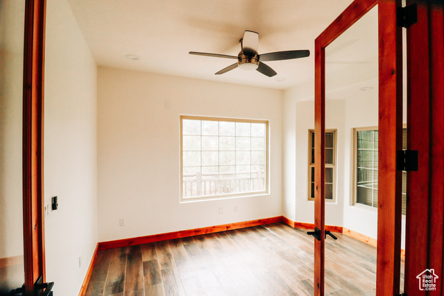 985 Russell Road Hatch, UT 84735 - Photo 13 of 30 Empty room featuring wood finished floors and a ceiling fan