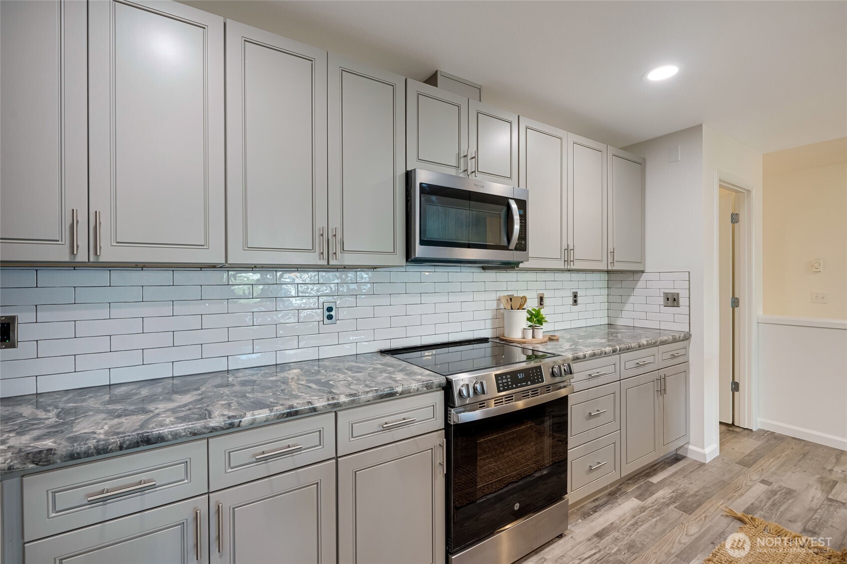4678 Wade Street, Unit 201 Bellingham, WA 98226 - Photo 10 of 25 a kitchen with granite countertop white cabinets stainless steel appliances and a sink