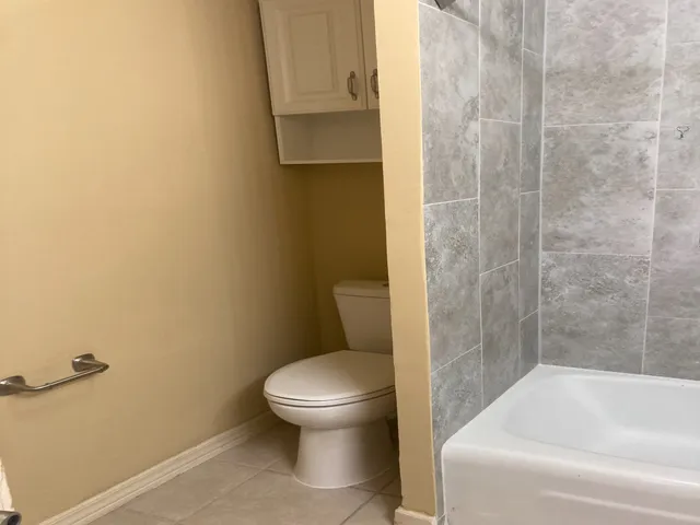 a white toilet sitting next to a bath tub
