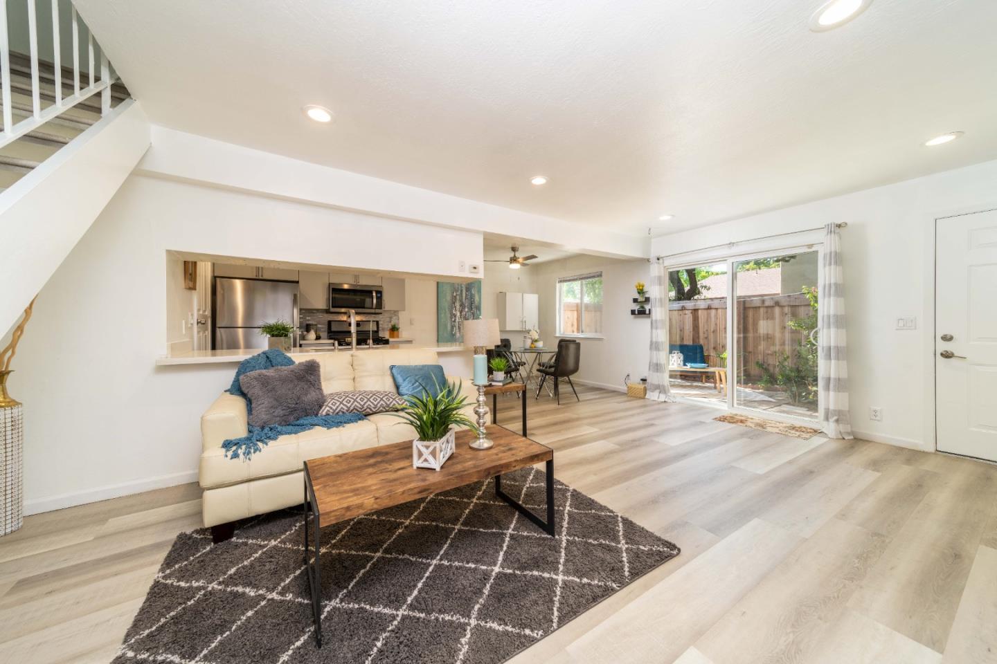 a living room with furniture a dining table and a potted plant