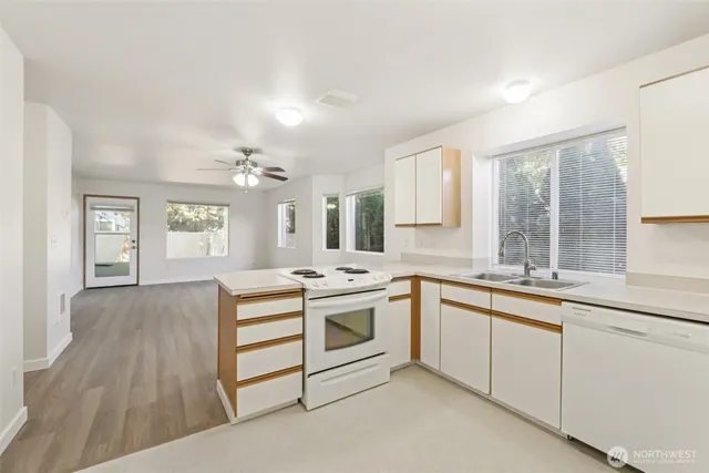 a kitchen with white cabinets and white appliances