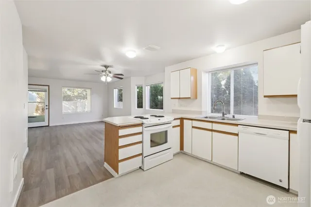 a kitchen with granite countertop a stove sink and cabinets