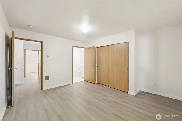 an empty room with wooden floor & windows