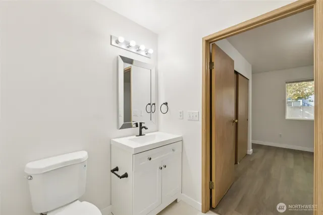 a bathroom with a toilet a sink and mirror