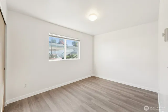 an empty room with wooden floor and window